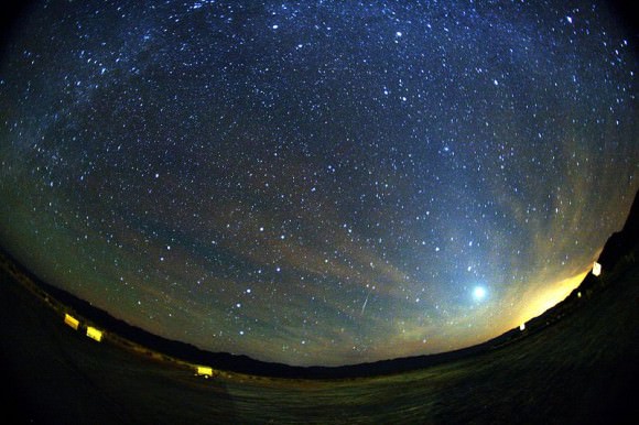 A green and red Orionid meteor striking the sky below Milky Way and to the right of Venus. Zodiacal light is also seen at the image The trail appears slightly curved due to edge distortion in the lens. Taken by Mila Zinkova