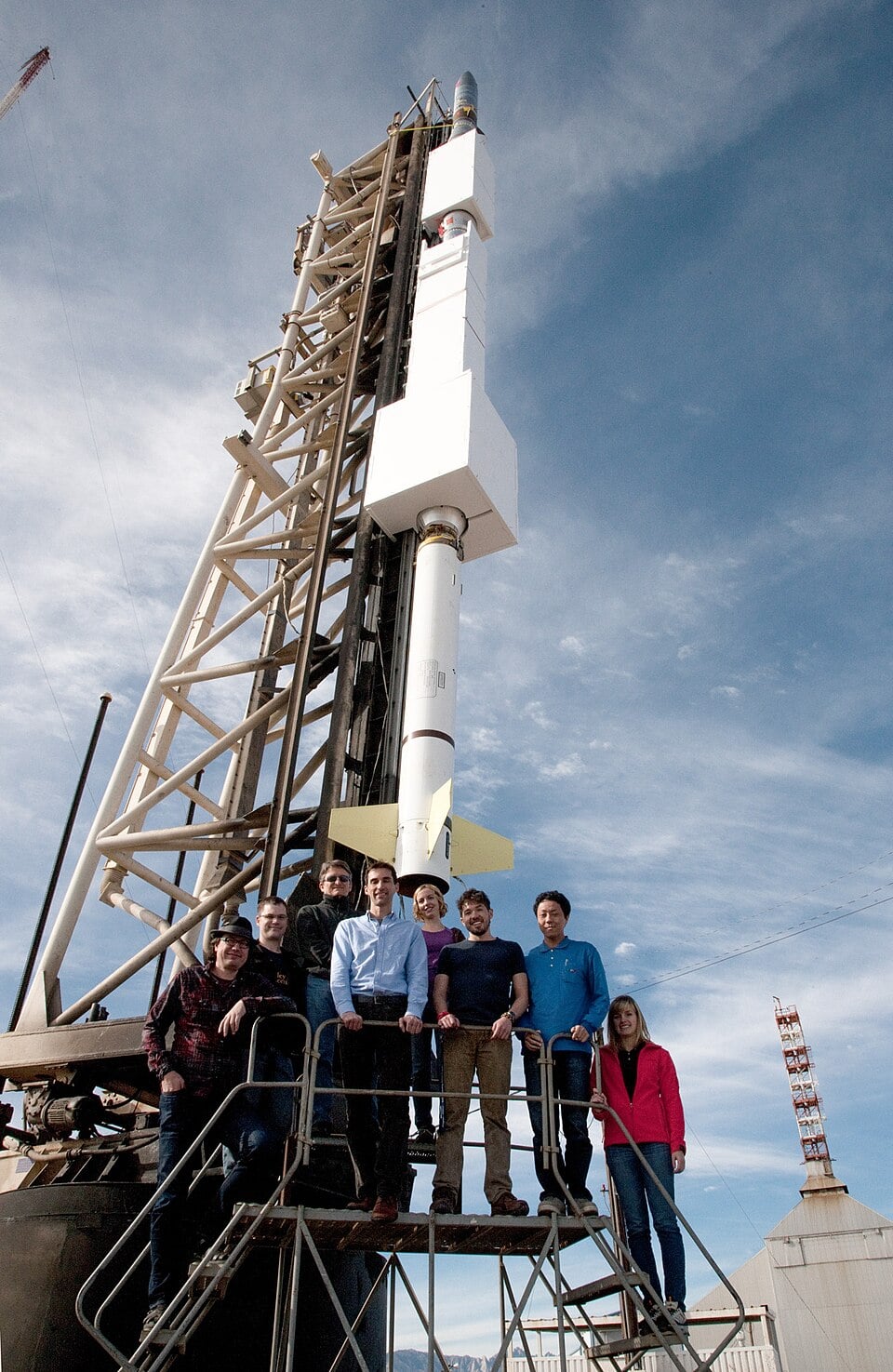 Uma fotografia da equipe FOXSI em frente a um foguete de sondagem FOXSI na plataforma de lançamento (Crédito: Governo Federal dos EUA).
