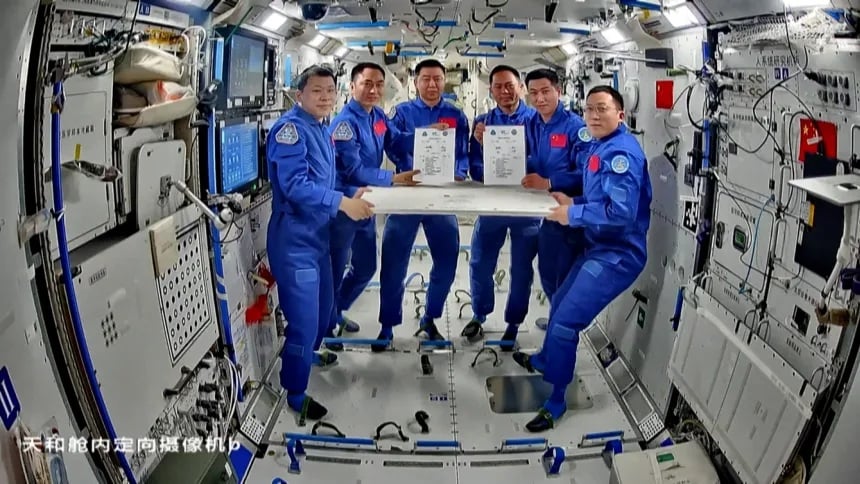 Crew members of Shenzhou-20 and Shenzhou-21 signing documents for work handover on board the Tiangong space station on November 4, 2025. Credit: CCTV