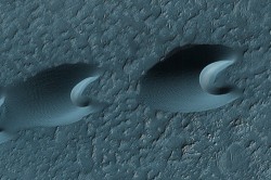 False color close-up of two sand dunes. Wind flow from left to right (NASA)