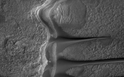 The down-wind slope of one of the eroded mesas, sand build-up obvious (NASA)