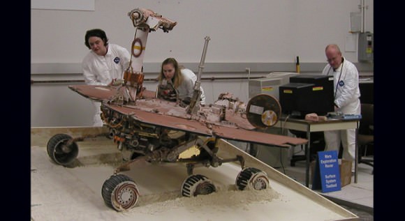 A test rover rolls off a plywood surface into a prepared bed of soft soil.  Credit: JPL