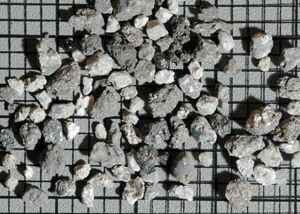 Small rock fragments from the lunar "soil" collected by the Apollo 11 astronauts in 1969. The background grid spacing is 2 mm.  Credit: WUSTL