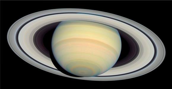 An image of Saturn from NASA's Cassini spacecraft, clearly showing the 'geographic' South Pole of the planet (at the center of the circle of clouds, lower left). The bulk rotation of the planet is around an axis passing through the South Pole and Saturn's clouds (of ammonia ice) are organised into dark 'belts' and light 'zones' that are generally aligned with lines of latitude, indicating the influence of the planet's rotation on its meteorology.
