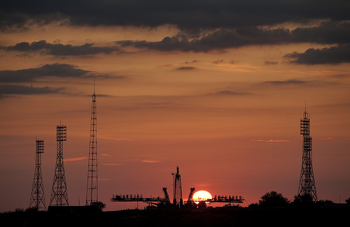 The sun rises behind the Soyuz launch pad shortly before the Soyuz rocket is rolled out.  Photo Credit: (NASA/Bill Ingalls)