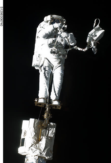Robert Satcher on the Canadarm2 during the first space walk of STS-129. Credit: NASA