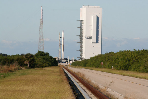 Atlas 5 rocket sits atop mobile launch platform at launch pad at Complex 41, Cape Canaveral, Florida on a cloudless day just a few hours prior to the scheduled post midnight launch on 14 November  2009.  Note lightings masts at left and Vertical Integration Facility at right where rocket components are assembled.  Credit: Ken Kremer