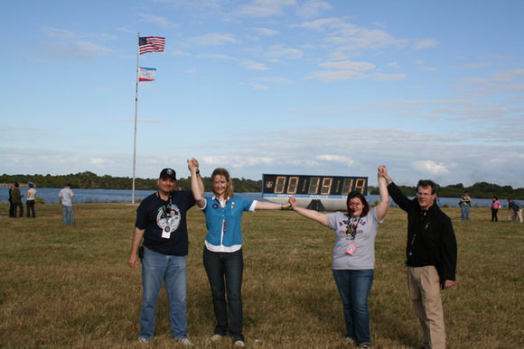 Ken Kremer met up with a group of lucky Tweeters at the KSC press center a few minutes after Atlantis blast off.  Back dropped by the world famous countdown clock, pad 39 A.  Do you think they are having a blast?   Credit: Ken Kremer