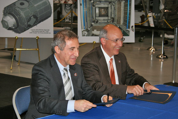 Bernardo Patti (left), the ESA space station manager for ESA and Michael Suffredini (right), the NASA space station manager sign Tranquility module ownership transfer documents inside the Space Station Processing Facility (SSPF) on 20 November 2009. Credit: Ken Kremer