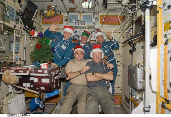 Expedition 22 crew of 5 Elite Santa helpers and elves wearing festive holiday hats inside the Zvezda Service Module adorned with Christmas tree. Credit: Santa