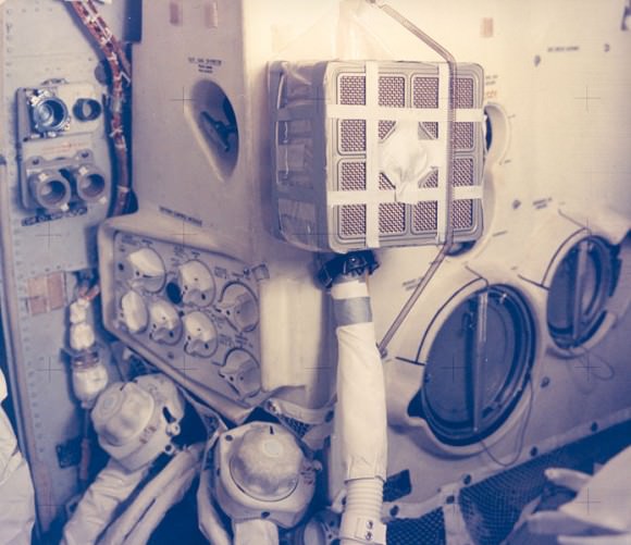 The Apollo 13 fix -- complete with duct tape -- of making a square canister fit into a round hole.  Credit: NASA
