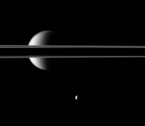 Saturn's rings, made dark in part as the planet casts its shadow across them, cut a striking figure before Saturn's largest moon, Titan.  Credit: NASA/JPL/Space Science Institute