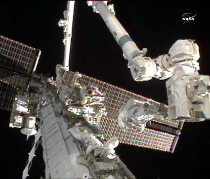 Image above: Expedition 24 Flight Engineers Doug Wheelock (right) and Tracy Caldwell Dyson work to replace a failed ammonia pump module outside of the International Space Station. Credit: NASA TV 