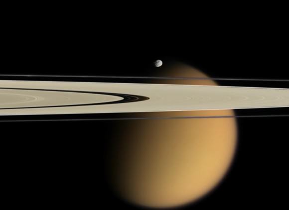 Titan peeks from behind two of Saturn's rings. Another small moon Epimetheus, appears just above the rings. Credit: NASA/JPL/Space Science Institute