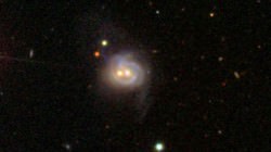 Viewed in visible light, Markarian 739 resembles a smiling face.  Inside are two supermassive black holes, separated by about 11,000 light-years. The galaxy is 425 million light-years away from Earth. Credit: Sloan Digital Sky Survey