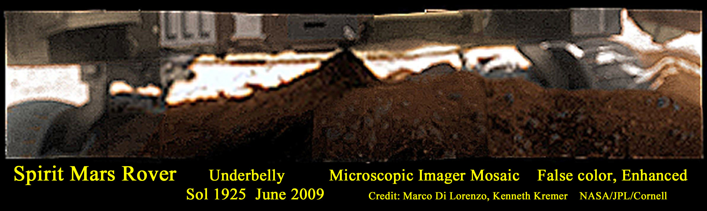 Mosaic of microscopic images of Spirit’s underbelly on Sol 1925 in June 2009.  Mosaic shows predicament of being stuck at Troy with wheels buried in the sulfate-rich Martian soil.  This false color mosaic has been enhanced and stretched to bring out additional details about the surrounding terrain and embedded wheels and distinctly shows a pointy rock perhaps in contact with the underbelly.   Mosaic Credit: Marco Di Lorenzo/ Kenneth Kremer/NASA/JPL/Cornell