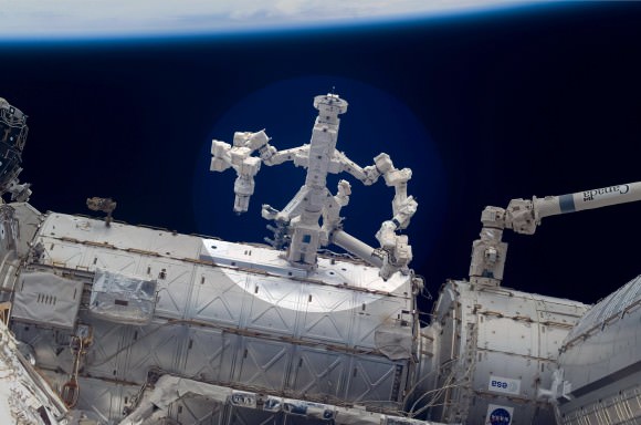 Canada’s Dextre robot (highlight) and NASA’s Robotic Refueling Experiment jointly performed groundbreaking robotics research aboard the ISS in March 2012.  Dextre used its hands to grasp specialized work tools on the RRM for experiments to repair and refuel orbiting satellites. Credit: NASA
