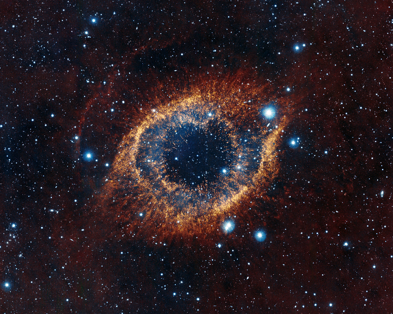 ESO's Visible and Infrared Survey Telescope for Astronomy (VISTA) has captured this unusual view of the Helix Nebula (NGC 7293), a planetary nebula located 700 light-years away. The coloured picture was created from images taken through Y, J and K infrared filters. While bringing to light a rich background of stars and galaxies, the telescope's infrared vision also reveals strands of cold nebular gas that are mostly obscured in visible images of the Helix. 