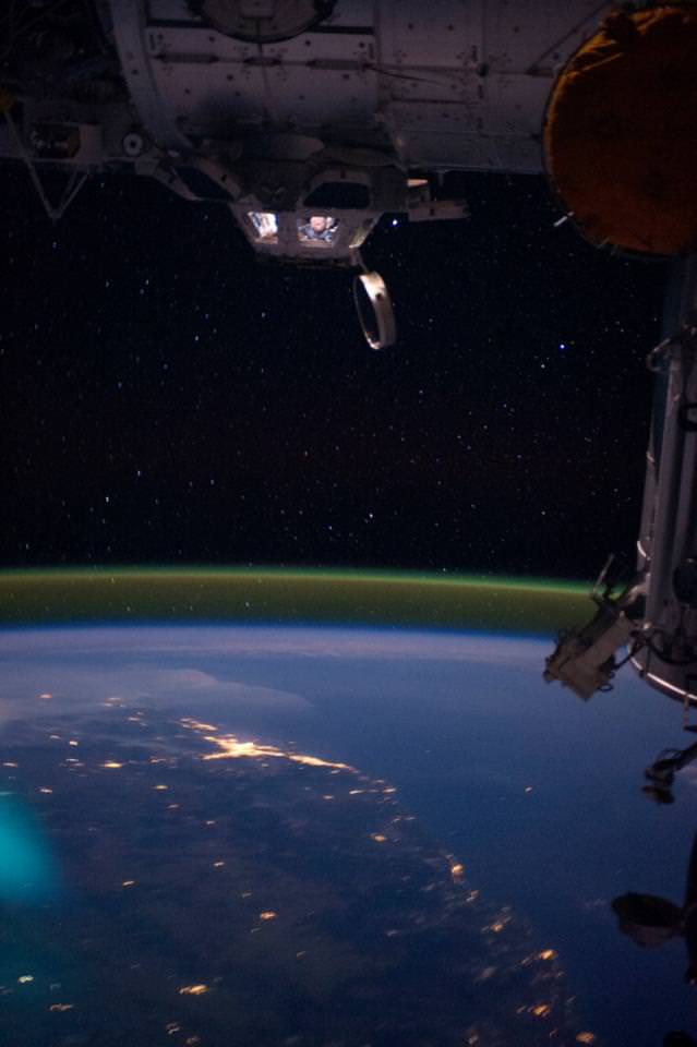NASA astronaut Ron Garan looking down at a night view of Australia from the International Space Station's cupola..