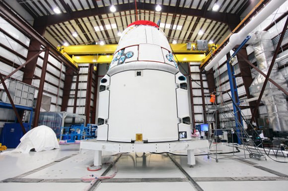 SpaceX, Dragon spacecraft stands inside a processing hangar at Cape Canaveral Air Force Station in Florida. Teams had just installed the spacecraft's solar array fairings. Credit: NASA/Kim Shiflett