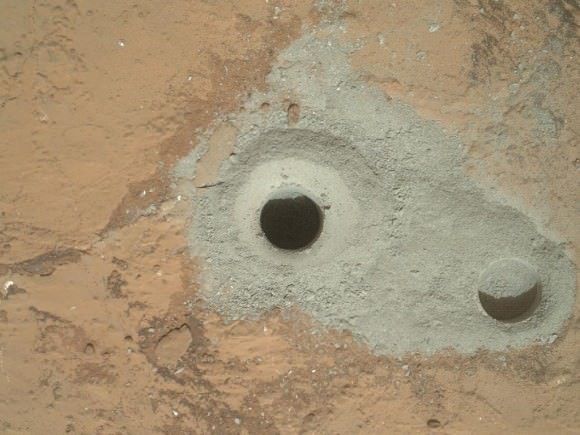Curiosity's First Sample Drilling hole is seen in this image at a rock called "John Klein". The drilling took place on Feb. 8, 2013, or Sol 182 of operations. Several preparatory activities with the drill preceded this operation, including a test that produced the shallower hole on the right two days earlier, but the deeper hole resulted from the first use of the drill for rock sample collection. The image was obtained by Curiosity's Mars Hand Lens Imager (MAHLI). The sample-collection hole is 0.63 inch (1.6 centimeters) in diameter and 2.5 inches (6.4 centimeters) deep. The "mini drill" test hole near it is the same diameter, with a depth of 0.8 inch (2 centimeters).  Credit: NASA/JPL-Caltech/MSSS