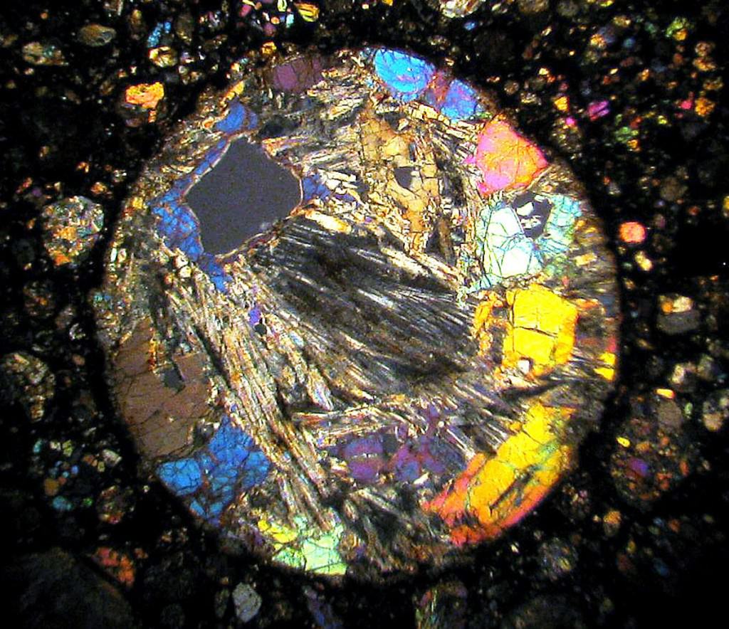 10x closeup of a very thin section through a chondrule in the meteorite NWA 4560. Crystals of olivine (bright colors) and pyroxene are visible. Credit: Bob King