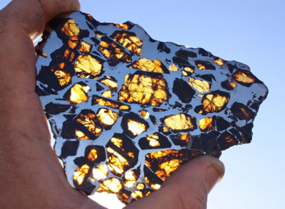 A stunning slice of the Glorieta pallasite meteorite cut thin enough to allow light to shine through its many olivine crystals.  Credit: Mike Miller