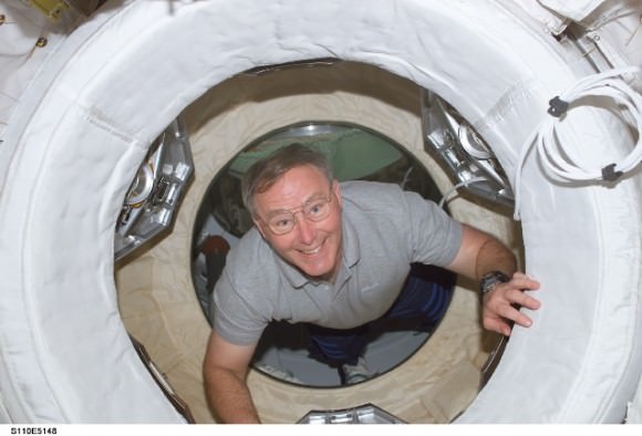Jerry Ross during the  STS-110 mission in 2002, coming through one of the many hatches on the International Space Station. Credit: NASA.