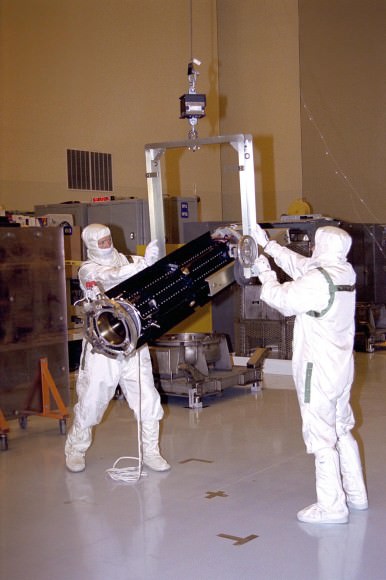 Technicians handle an RTG at the Payload Hazardous Servicing Facility at the Kennedy Space Center for the Cassini spacecraft. (Credit: NASA).
