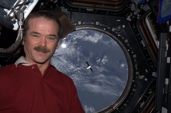 Hadfield's self-portrait in the Cupola with rising Dragon below, Africa behind. Credit: NASA/Chris Hadfield. 