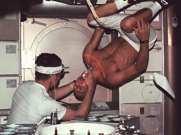 Undergoing a Dental Exam in Space Skylab 2 commander Pete Conrad undergoes a dental examination by medical officer Joseph Kerwin in the Skylab Medical Facility. In the absence of an examination chair, Conrad simply rotated his body to an upside down position to facilitate the procedure. Credit: NASA