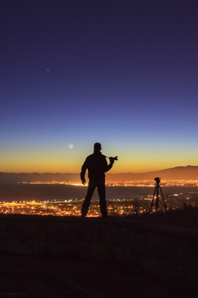 A silhouette of photographer Miguel Claro along with the crescent Moon and Jupiter. Credit and copyright: Miguel Claro. 