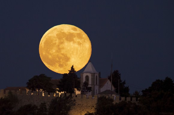 The perigee 'Super Moon' of June 23, 2013 as seen over Sesimbra, Portugal and the church Nossa Senhora do Castelo.  Credit and copyright: Miguel Claro. 