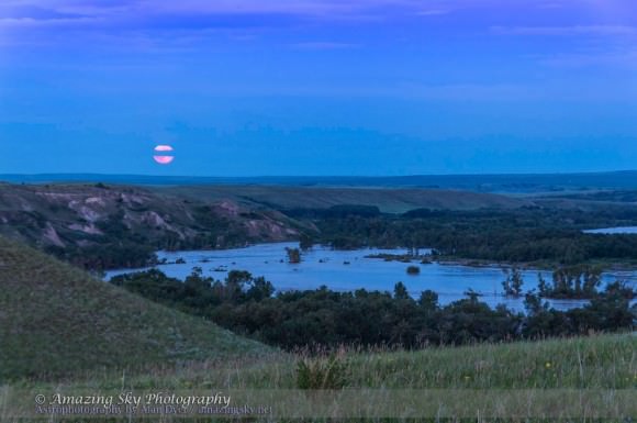 The perigee Super Moon rising over the floodwaters of the Bow River during a record flood that inundated many parts of southern Alberta around rivers, including here on the Siksika First Nations reserve. Credit and copyright: Alan Dyer/Astronomy Calgary/Amazing Sky Photography.