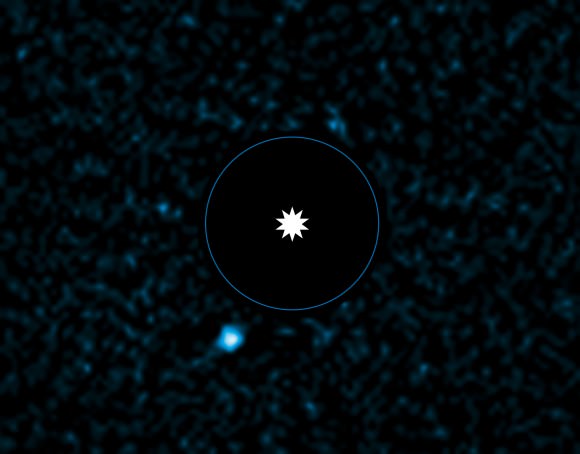 Planet HD95086 b is shown at lower left in this picture. Astronomers blocked out the light of the star (center) to image the exoplanet. The blue circle represents the equivalent orbit of Neptune in this star system. Credit: ESO/J. Rameau
