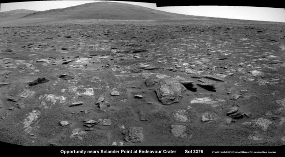Opportunity rover moves closer to the foothills of Solander Point along the rim and vast expanse of Endeavour Crater.  The rover investigated one of the large rocks here with her microscopic imager and X-Ray spectrometer. Soon she will start climbing up Solander -  her 1st Martian Mountain ascent.  This navcam panoramic mosaic was assembled from raw images taken on Sol 3376 (July 23, 2013).  Credit: NASA/JPL/Cornell/Marco Di Lorenzo/Ken Kremer (kenkremer.com)