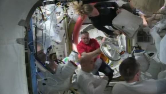 ISS Astronauts gather in the Quest airlock  after water leaked inside Luca Parmitano's spacesuit. Via NASA TV. 