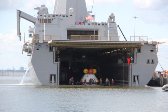 Dive teams haul Orion onto the well deck of the USS Arlington during Aug. 15 recovery test at Norfolk Naval Base, VA.  Credit: Ken Kremer/kenkremer.com