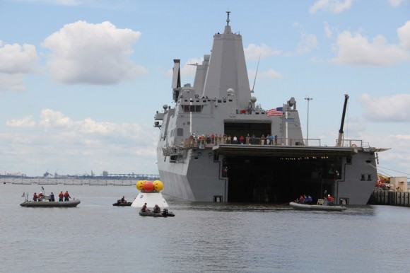 US Navy divers on four boats attached tow lines and to the Orion test capsule and guide it to the well deck on the USS Arlington during Aug. 15 recovery test Norfolk Naval Base, VA.  Credit: Ken Kremer/kenkremer.com