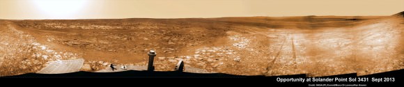 Opportunity starts scaling Solander Point - her 1st mountain climbing goal. See the tilted terrain and rover tracks in this panoramic view from Solander Point peering across the vast expanse of huge Endeavour Crater.  Opportunity will ascend the mountain looking for clues indicative of a Martian habitable environment.  This navcam camera mosaic was assembled from raw images taken on Sol 3431 (Sept.18, 2013).  Credit: NASA/JPL/Cornell/Marco Di Lorenzo/Ken Kremer (kenkremer.com). 