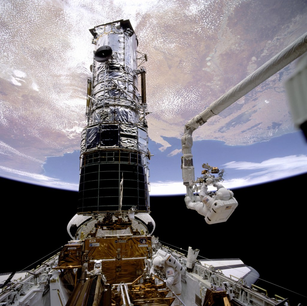 NASA astronaut Story Musgrave rides the Canadarm during the Hubble Space Telescope repair mission STS-61, in 1993. Credit: NASA