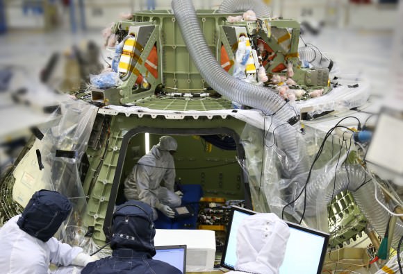 Technicians work inside the Orion crew module being built at Kennedy Space Center to prepare it for its first power on. Turning the avionics system inside the capsule on for the first time marks a major milestone in Orion’s final year of preparations before its first mission, Exploration Flight Test 1 Credit: Lockheed Martin 