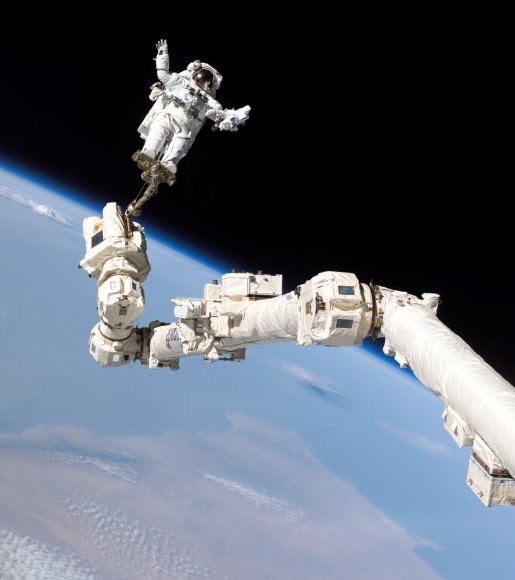 STS-114 NASA astronaut Steve Robinson in 2005 aboard Canadarm2, a robotic arm designed specifically for International Space Station construction. Canadarm2 was installed during STS-100 in 2001. It took more than 1,000 hours of spacewalking assembly to put the station together. Credit: NASA