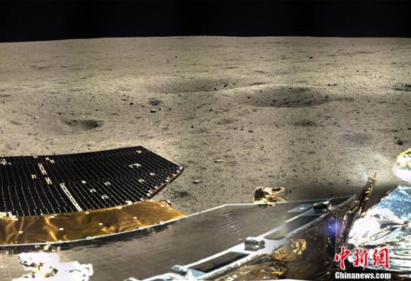 The lander's solar panels stand out in the foreground with a smattering of small craters nearby. Credit: Chinanews.com