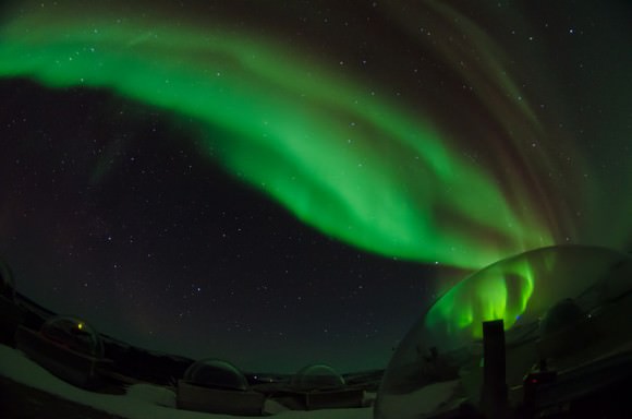 An aurora rising from the east above the Science Operations Center at Poker Flat. Aurora seen in Alaska on Feb. 28, 2014. The bubble in the lower right is a dome housing a scientific camera which happens to be in just the right spot to appear as if it's blowing the aurora out. Credit and copyright: Jason Arhns. 
