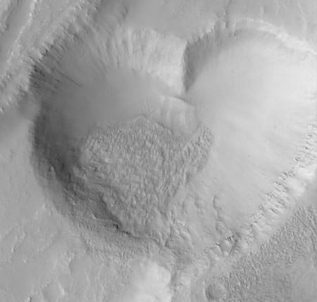 This heart-shaped feature on Mars "is actually a pit formed by collapse within a straight-walled trough known in geological terms as a graben," wrote Malin Space Systems in 1999. Picture taken by Mars Global Surveyor. Credit: Malin Space Science Systems, MGS, JPL, NASA