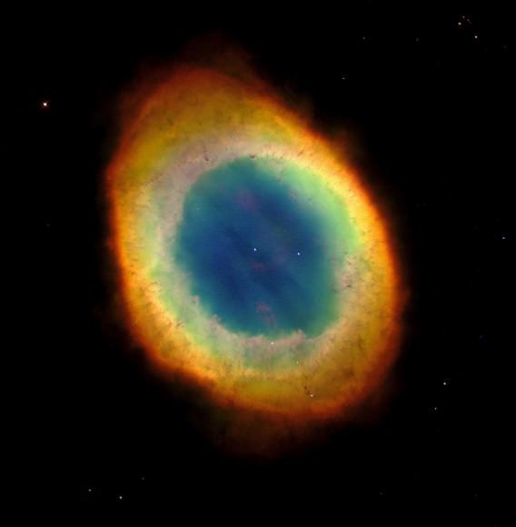 This planetary nebula's simple, graceful appearance is thought to be due to perspective: our view from Earth looking straight into what is actually a barrel-shaped cloud of gas shrugged off by a dying central star. Hot blue gas near the energizing central star gives way to progressively cooler green and yellow gas at greater distances with the coolest red gas along the outer boundary. Credit: NASA/Hubble Heritage Team