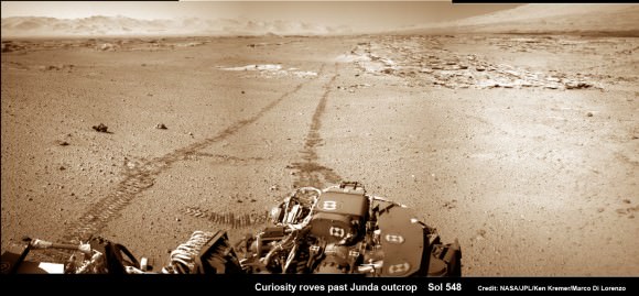 Curiosity looks back at Martian sand dunes and rover tracks after passing by Junda outcrop (right) on Sol 548 (Feb. 19, 2014) with Gale Crater rim and Mount Sharp on the distant horizon. Navcam colorized photomosaic. Credit: NASA/JPL-Caltech/Ken Kremer- kenkremer.com/Marco Di Lorenzo 