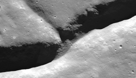 In this photo, we come in for a closer look at the fracture or rill in Karpinskiy's floor. Notice the boulders on the cliff side. Credit: NASA