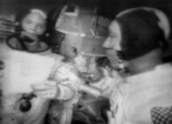 Apollo 9 commander Jim McDivitt (right) drinks from a hand water dispenser while lunar module pilot Rusty Schweickart looks on. Photo is a still from a March 1969 television broadcast. Credit: NASA
